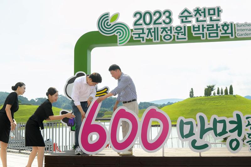 관람객 600만 명을 돌파를 축하하는 행사에서 노관규 순천시장과 정병회 순천시의회의장이 관람객 수 앞자리를 600만으로 바꾸고 있다